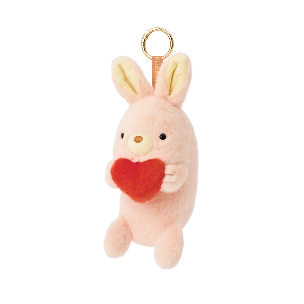 Product image shows Posture Pal Bag Charm, Rabbit variant with a brown tag and gold circle clip. Rabbit is light pink and cream colored, holding a red plush heart between its hands.
