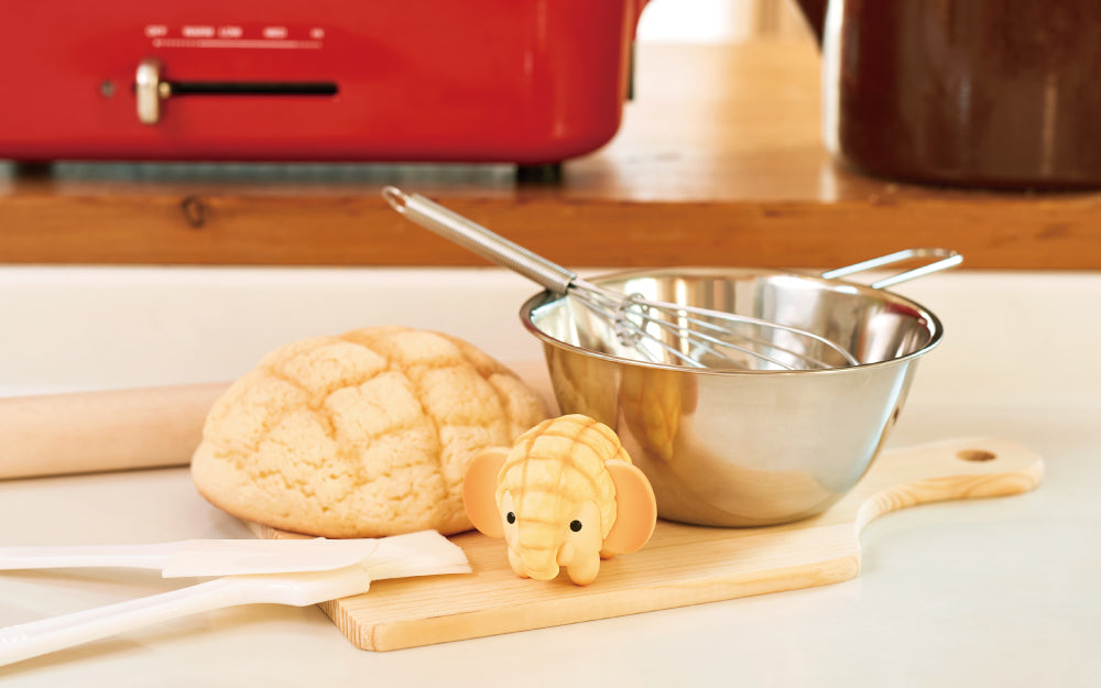 animal bakery mini figure elephant on a kitchen counter with mixing bowl, whisk, and melonpan props