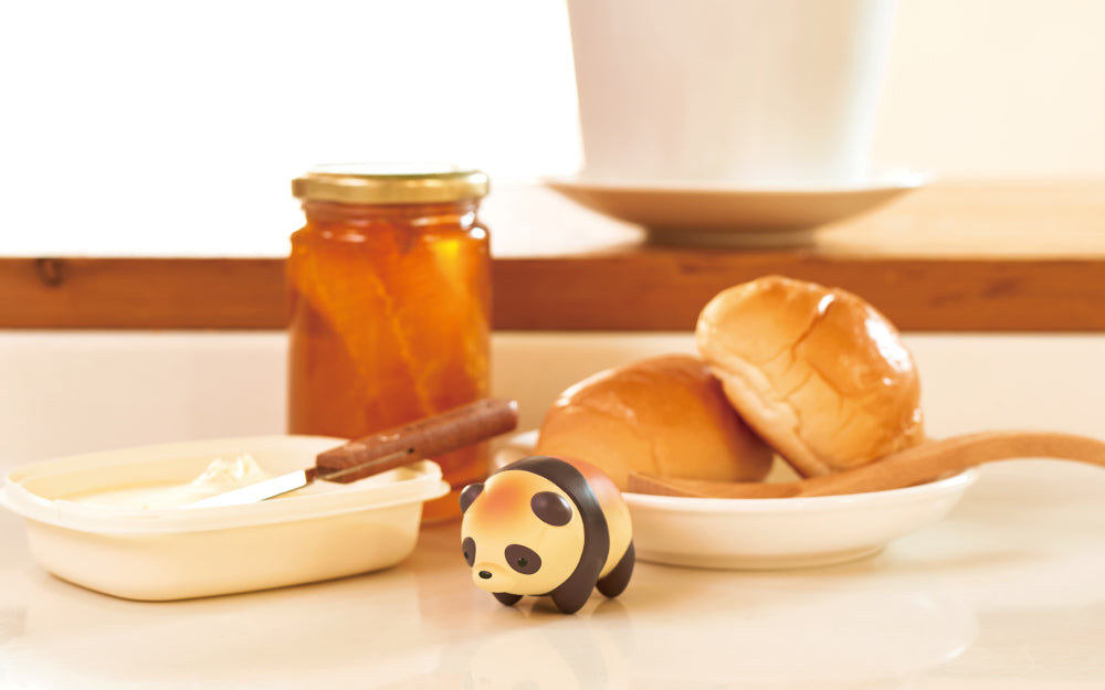 animal bakery panda mini figure on a kitchen counter with butter, roll, and jam props