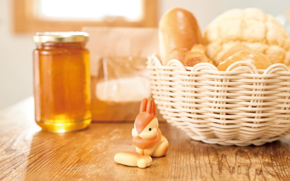 animal bakery bunny mini figure on a kitchen table with carrot accessory and bread basket, jam, and bag props