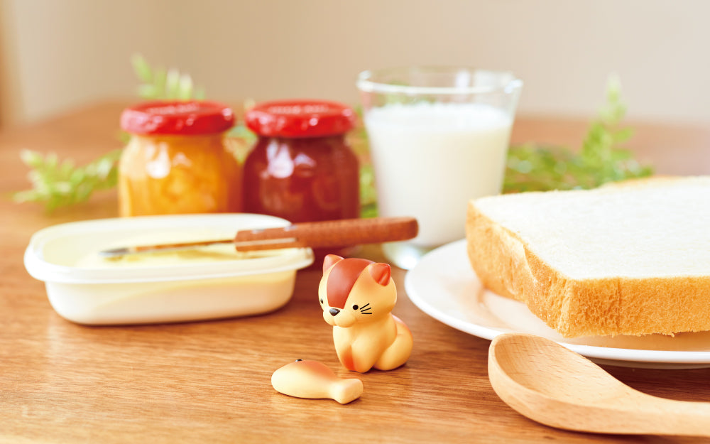 animal bakery mini figure cat on a kitchen table with fish accessory and butter, bread, jam, and milk props