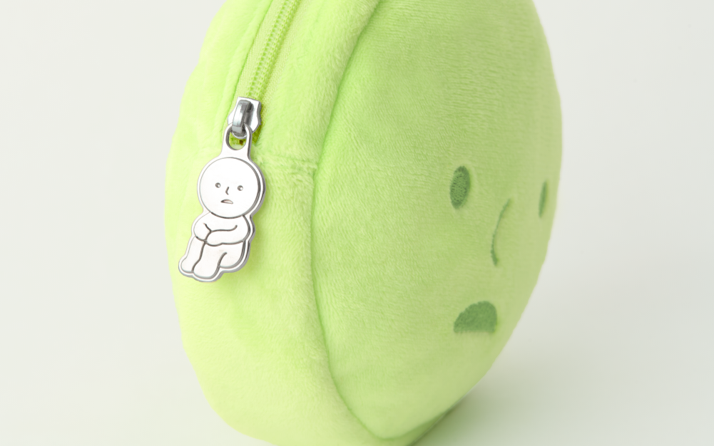 Set on white background. Green SMISKI Cushion Pouch set sideways to display silver Hugging Knees zippper pull design