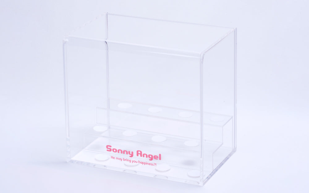 Sonny Angel Display Case; branded with Sonny Angel logo and slogan "He may bring you happiness?!". Clear acrylic case shows risers with spaces for minifigures
