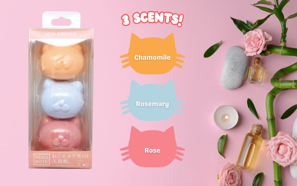 Dreams product Neko Mote bath bombs product image shows "3 Scents" with a product image as well as icons indicating the scented bath bombs. "Chamomile, Rosemary and Rose" scents included. Image also shows bamboo, rose blossoms and a vial of oil