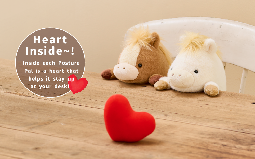Image shows both variants of the new Posture Pal Horse. Two plush horses, left: brown, right: white sit atop a white wooden chair at a wooden table. A plush red heart sits atop the table. Text reads "Heart inside~! Inside each Posture Pal is a heart that helps it stay up at your desk!"