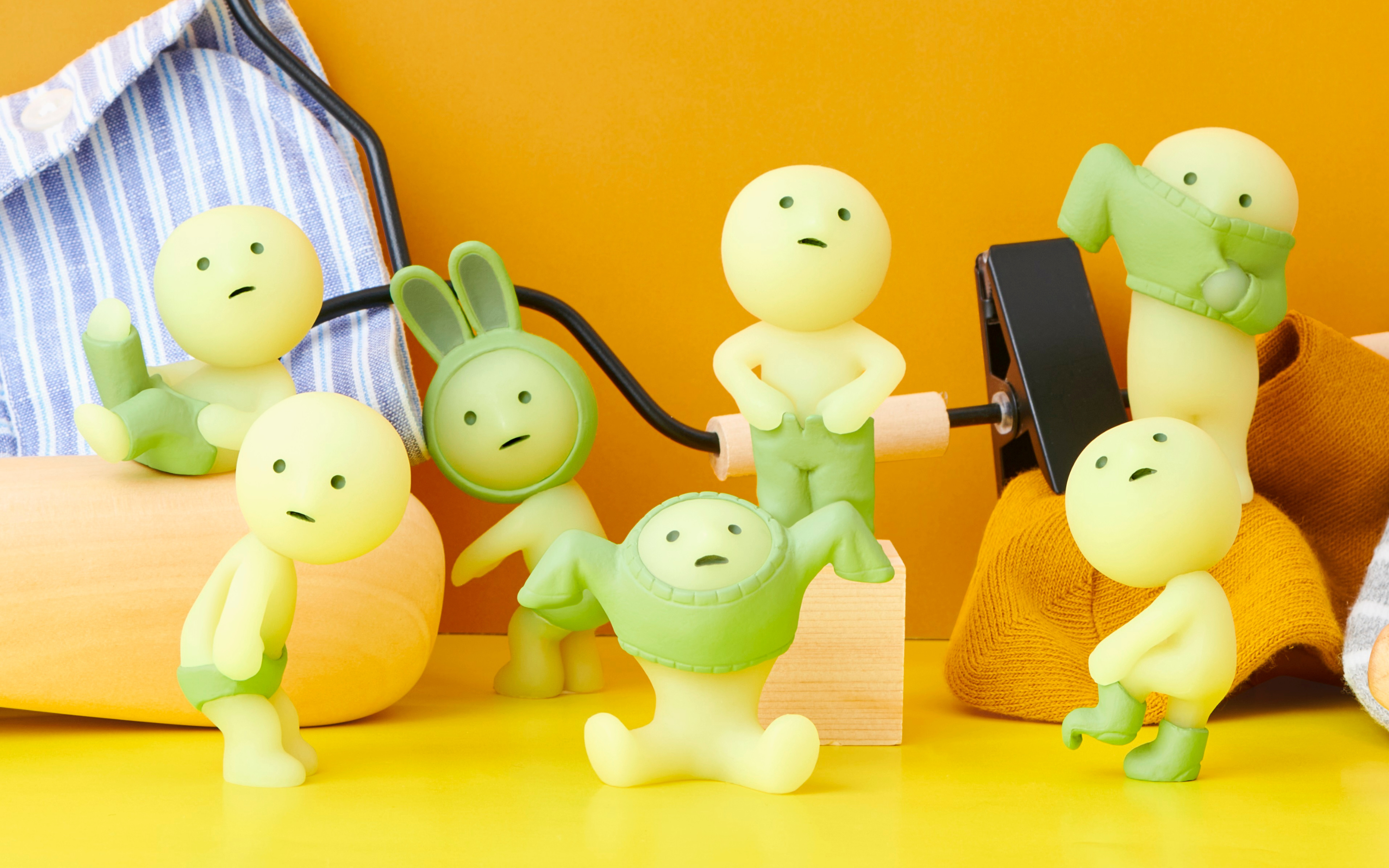 closeup of smiski dressing lineup on orange background surrounded by laundry-themed props
