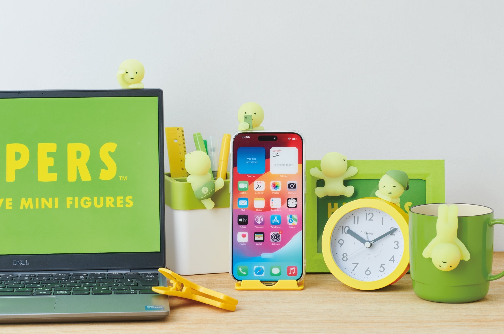 product lifestyle image for the smiski hippers minifigure series featuring the main lineup. from left to right: looking out attached to laptop; climbing attached to pencil holder; on his phone attached to a phone case; sticking attached to a picture frame; dozing attached to an analog clock; upside down attached to a mug.