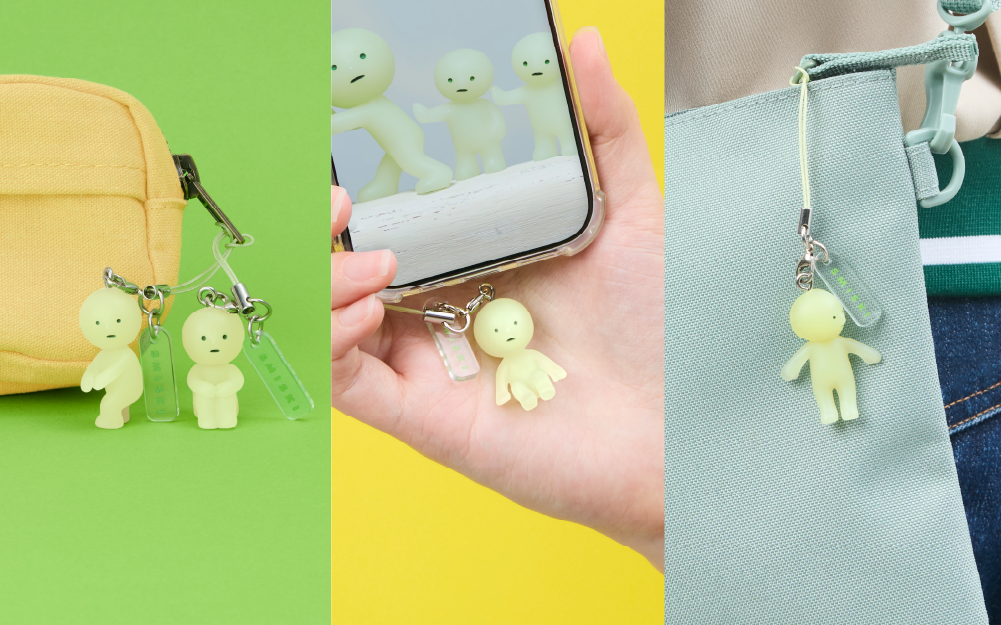 smiski strap accessory lifestyle image split into three parts. left: smiski looking back and smiski hugging knees strap accessories attached to a beige zipper pouch on a green background. center: person holding a smart phone in their hand with smiski sitting strap accessory attached to the case; right: person holding a blue shoulder bag with smiski hiding strap accessory attached to the zipper 