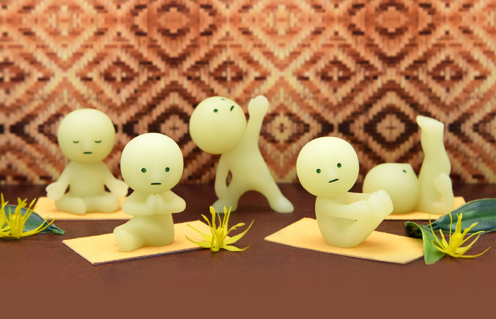 lifestyle product image of smiski yoga series in poses on a colorful set with fake plants and mats