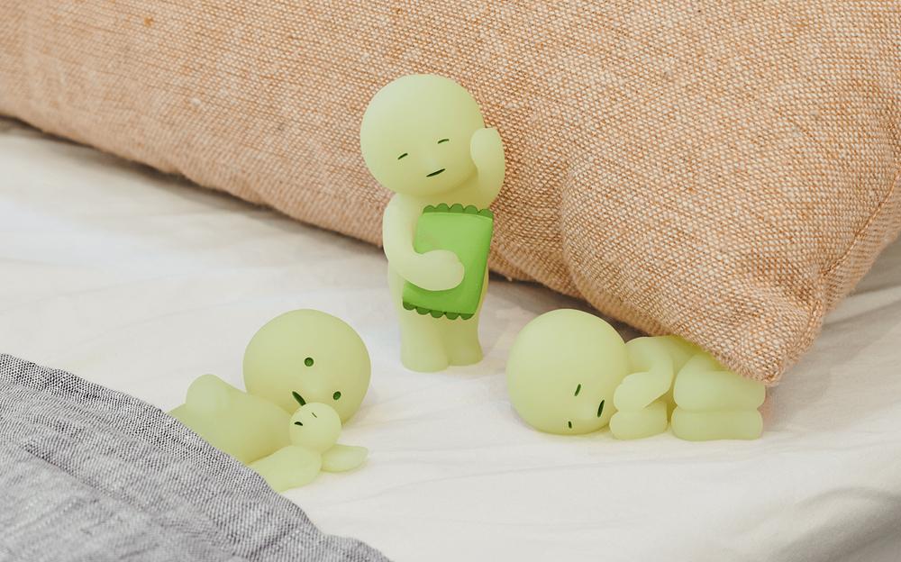 closeup of smiski cuddle, sleepy, and goodnight on a bed background