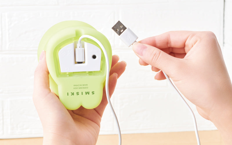 view of bottom of touch light vol 1 showing the charging micro-usb cable attached