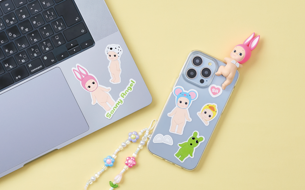sonny angel stickers on a phone case and laptop. the phone includes a sonny angel looking back rabbit figure