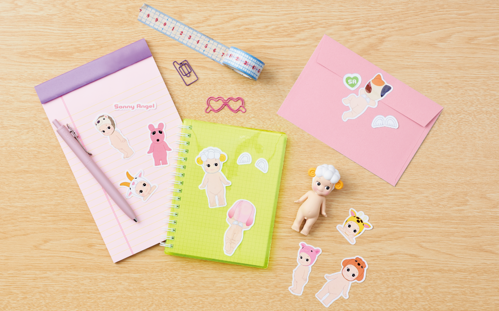 sonny angel sticker pack vol 1 stickers on a notepad, notebook, and envelope on a desk background