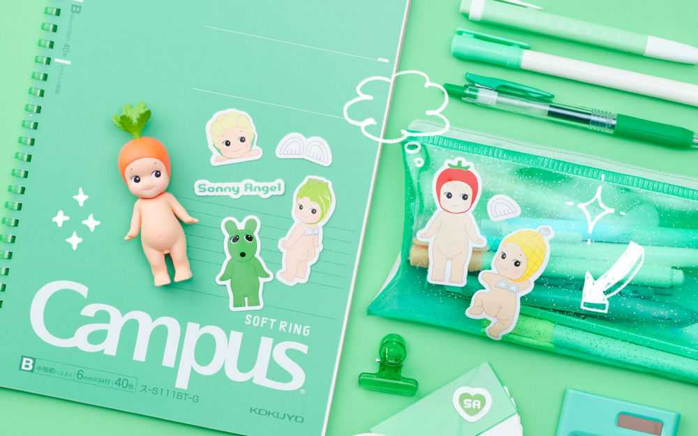 product lifestyle image for the sonny angel sticker pack series 2 products featuring die-cut stickers from the vegetable series placed on various stationary items, including a CAMPUS notebook and a vinyl pencil pouch. the overall theme of the image is GREEN and there are small doodle accents on the image. there is one carrot sonny angel mini figure in the center left of the image.