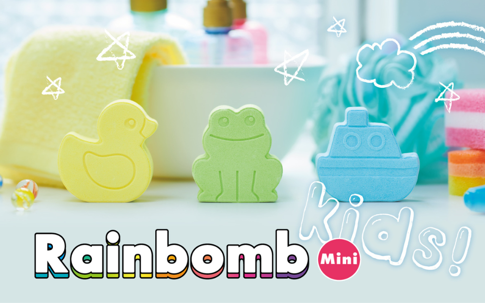 An image featuring three mini bath bombs shaped like a duck, boat, and frog, in a pastel color palette with the text 'Rainbomb Mini' and 'kids!' prominently displayed.