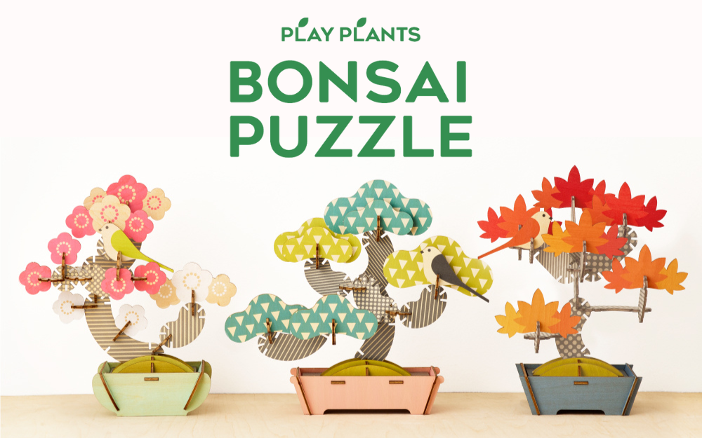 Three assembled bonsai puzzles with colorful leaves in various shapes displayed side by side.