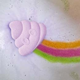 product closeup of rainbomb poop emoji purple grape in water surrounded by purple foam with a tail of green, pink, and orange