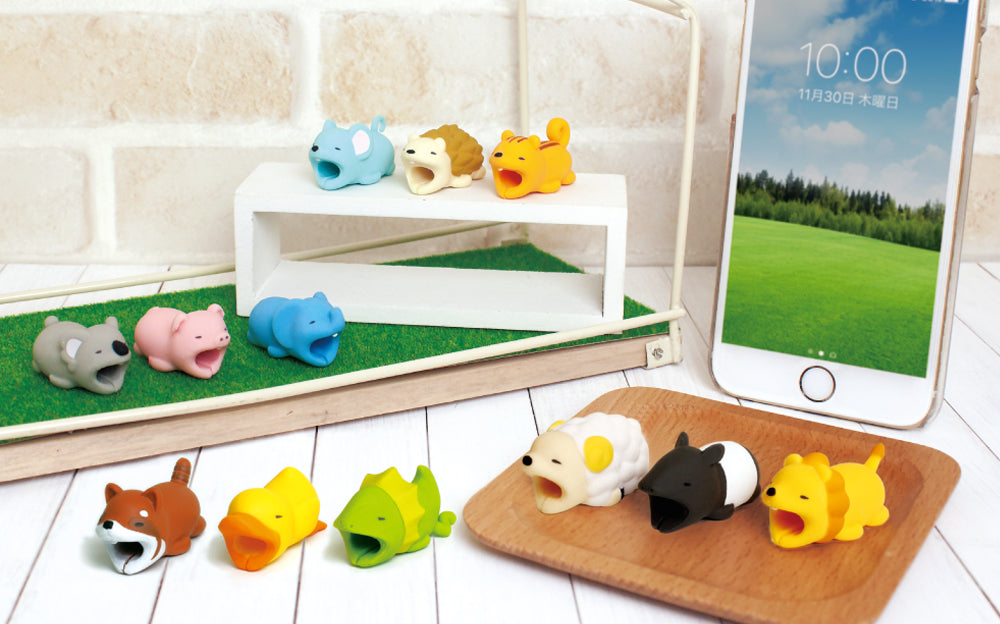 Image shows all product variants for Cable Bite Volume 2 alongside a white iPhone. From top to bottom, left to right: Koala, Pig, Elephant, Mouse, Hedgehog, Squirrel, Lesser Panda, Duck, Frilled Lizard, Sheep, Malayan Tapir, and Lion