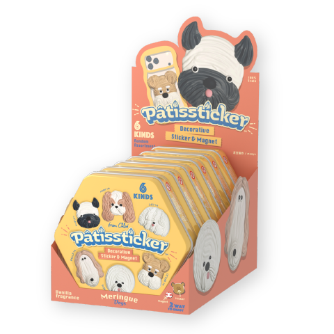 Product image set against a white background shows Patissticker full box packaging showing the product tins lined up in the display box. Display box prominently shows black and white short nosed dog beside a cell phone case showing product placement